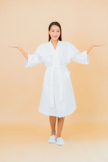 韩国肖像美丽的亚洲年轻女子穿着米色的微笑浴袍女士护肤亚洲
