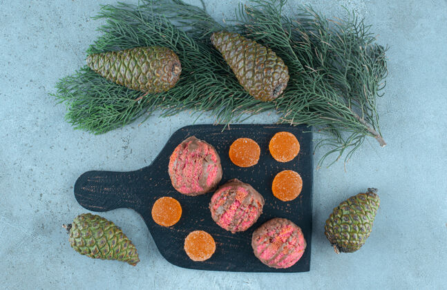 糖松果围在木板上 甜点放在大理石上烘焙食品松树甜点