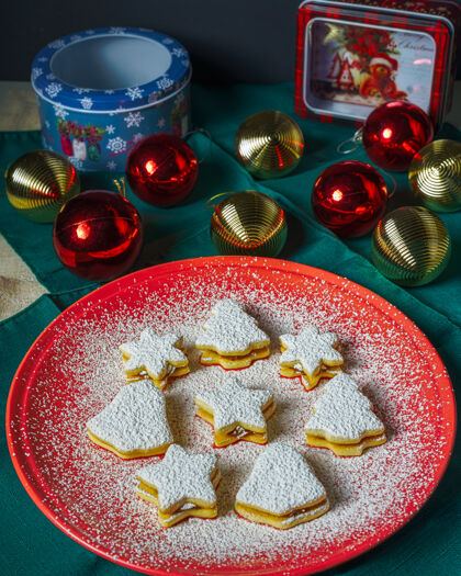 形状圣诞树 铃铛和星星饼干覆盖着糖粉甜点闪亮粉末
