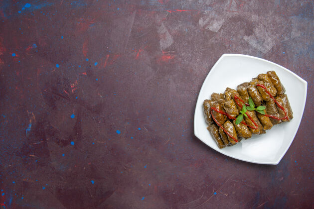 肉在黑暗的地板上的盘子里俯瞰美味的叶子多尔玛肉末菜食物蔬菜盘子