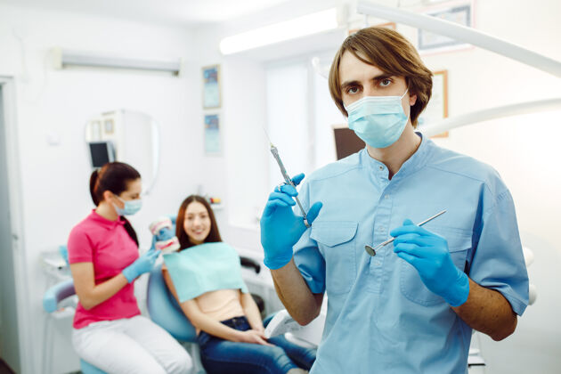 人麻醉师在牙科诊所摆着注射器的姿势年轻外科医疗保健