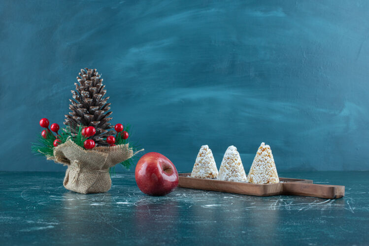 糖三个香草蛋糕 一个苹果和一个蓝色的圣诞装饰品美味粉末蛋糕