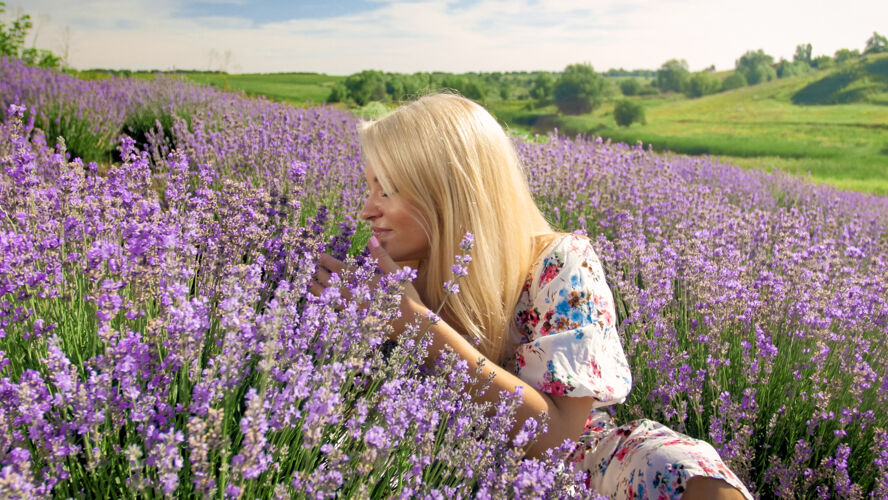 法国普罗旺斯薰衣草地上 一位微笑的年轻女子在闻花香景观散步天空