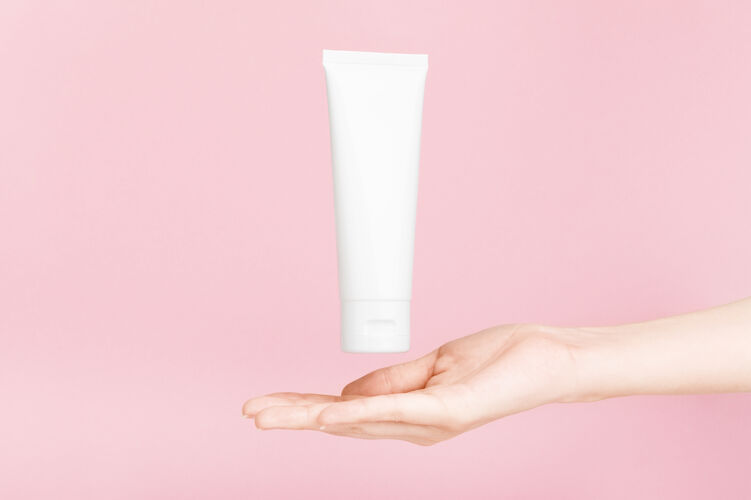 产品女性手拿着金冠奶油的flacon塑料flacon用于润肤露 洗漱液美容帽子Visagiste