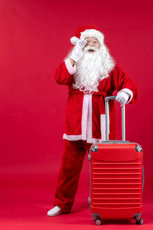 快乐红墙上的圣诞老人和他的红包的正视图节日礼物十二月