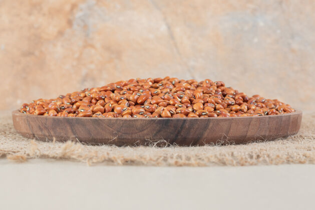 清淡棕色的豆子被隔离在混凝土的木板上极简素食甜味