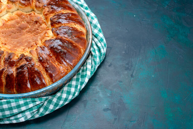 面团半顶视图美味的烤蛋糕圆形形成甜在浅蓝色桌子上的玻璃锅里糕点糖蛋糕