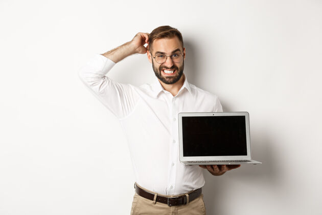 衬衫笨拙的商人展示笔记本电脑屏幕 神情可疑 站在白色背景下不舒服头发笔记本电脑经理