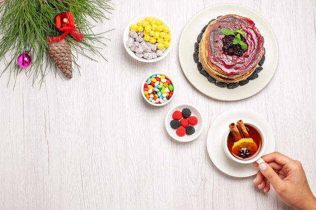 果冻俯瞰美味的果冻煎饼 加上糖果和一杯白茶晚餐糖果蛋糕