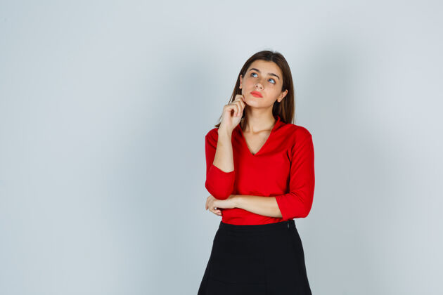 办公室穿着红衬衫 裙子的年轻女士站在思考的姿势 看起来沉思站立员工沉思