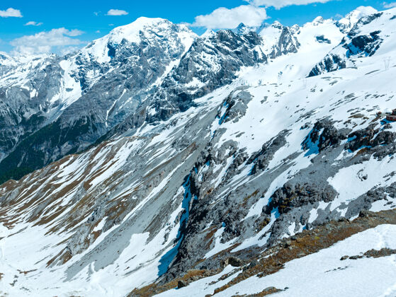 风景从斯泰尔维奥山口俯瞰夏日山景 山坡上有雪（意大利）路雪天气