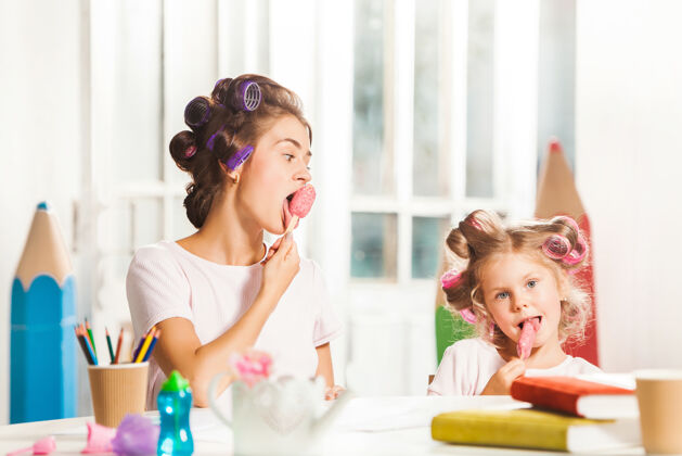 肖像小女孩和妈妈坐在一起吃冰淇淋童年女人化妆品
