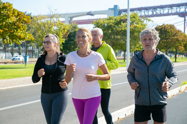 兴奋快乐疲惫的成熟慢跑者穿着运动服在户外跑步 参加马拉松训练 享受晨练退休老人和积极的生活方式理念中等射击活动男人