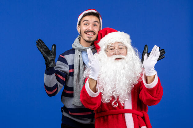 礼物前视图圣诞老人和年轻的男性服装圣诞老人年轻