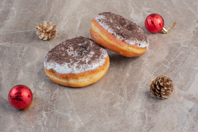 糖美味的甜甜圈旁边有圣诞树装饰和大理石上的松果美味美味美味