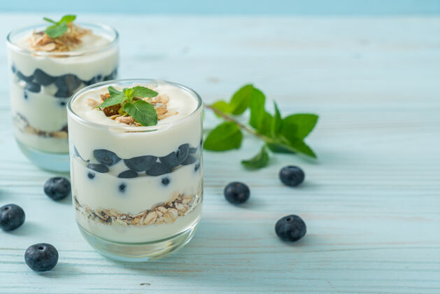 奶油新鲜的蓝莓和酸奶与格兰诺拉麦片-健康的食物风格木材浆果种子