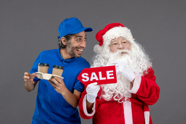 帽子圣诞老人的正面图 男信使拿着售货笔 灰色墙上挂着咖啡圣诞销售咖啡