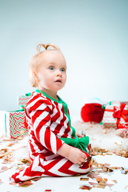 房间可爱的女婴1岁左右的圣诞老人帽子摆姿势圣诞老人礼物年轻