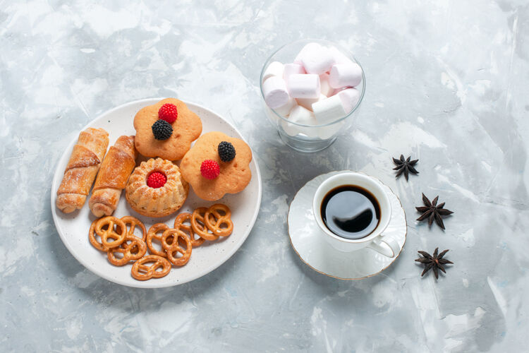 甜点在浅白的桌子上俯瞰美味的百吉饼 饼干 蛋糕和茶杯子百吉饼食物