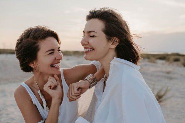 取向微笑的两位年轻女性朋友在日落海滩上玩得很开心 男女同性恋爱情浪漫女人Lgbtq女孩