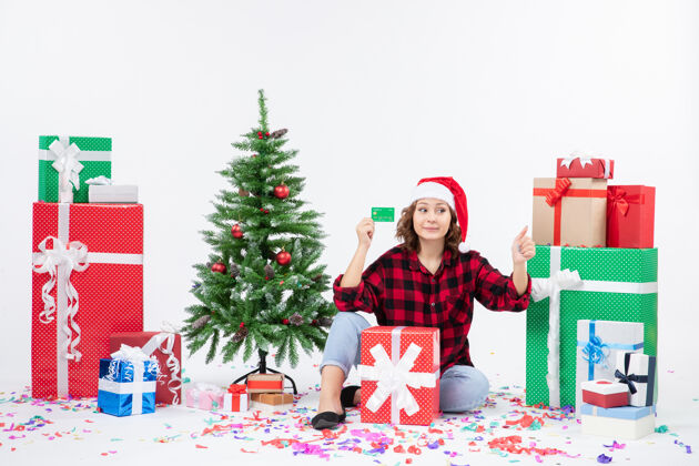 人前视图年轻女子围坐在一个白色的墙上拿着绿色银行卡的礼物购物雪十二月