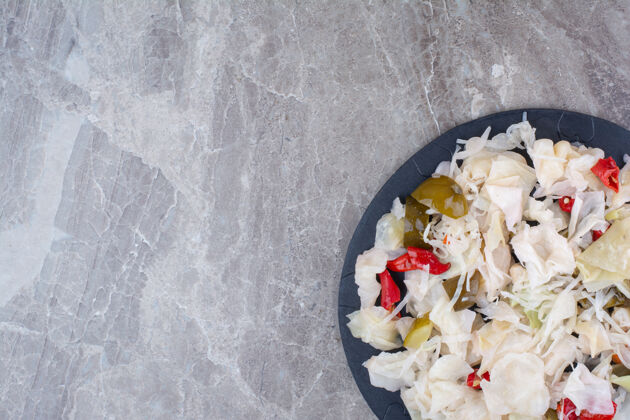 沙拉腌白菜和各种蔬菜放在深色盘子里顶视图各种视图