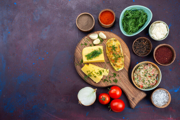 烘焙在黑暗的书桌上俯瞰烤南瓜和芝士绿 调味料 肉末和新鲜蔬菜午餐顶部肉