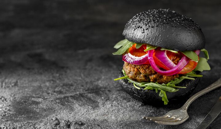 汉堡包前视图蔬菜汉堡与黑色面包在砧板上复制空间快餐菜单膳食