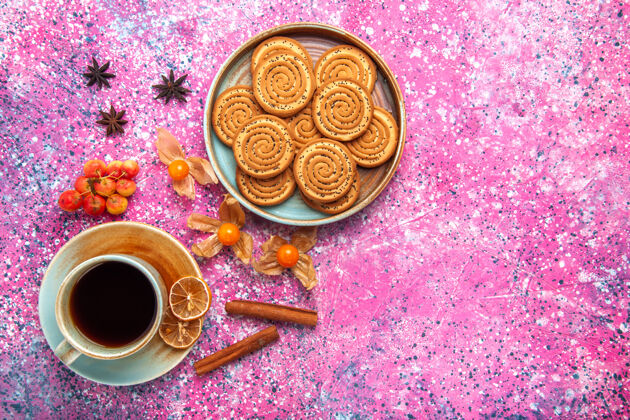 饼干顶视图甜饼干内与茶杯和肉桂粉红色的表面盘子里面美味糖
