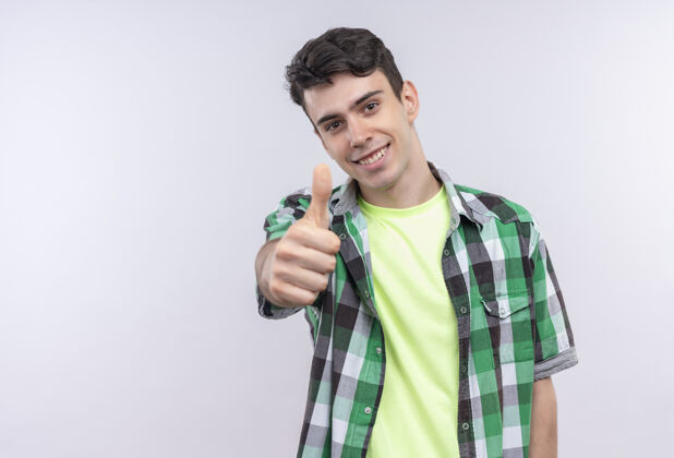 拇指微笑的白人年轻人穿着绿色衬衫 大拇指竖起在白色的背景上家伙年轻向上