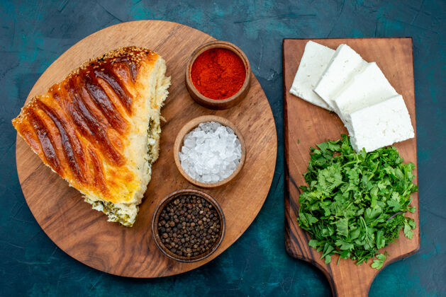 烘焙俯瞰美味的烤糕点切片与绿色填充调味品和白奶酪在黑暗的桌子上糕点盘子奶酪