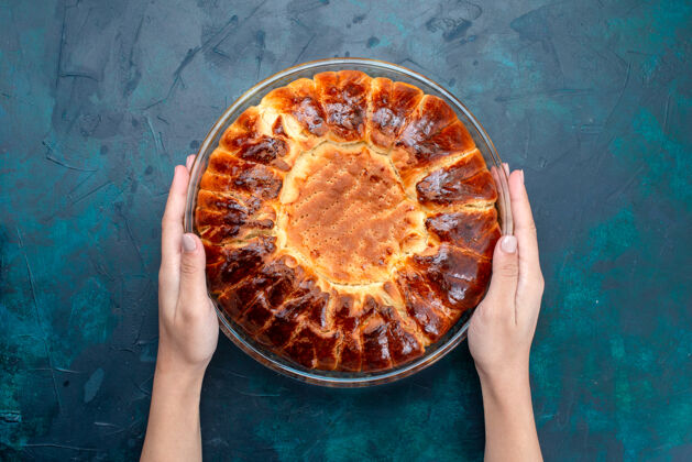 糕点顶视图美味的烤蛋糕圆形形成甜内浅蓝色背景上的玻璃锅菜面团圆的