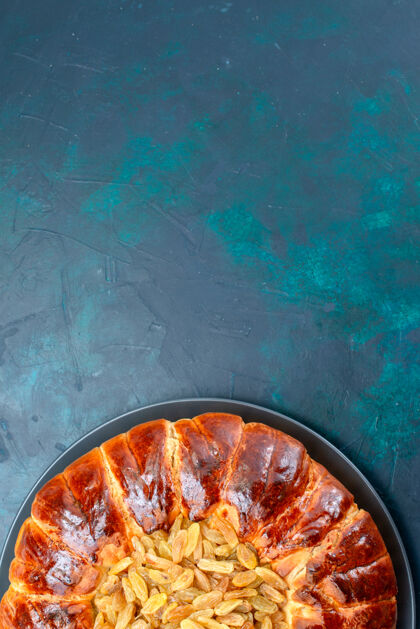 葡萄干俯视图美味的烤蛋糕圆形形成甜葡萄干在淡蓝色的背景顶部糕点烘焙