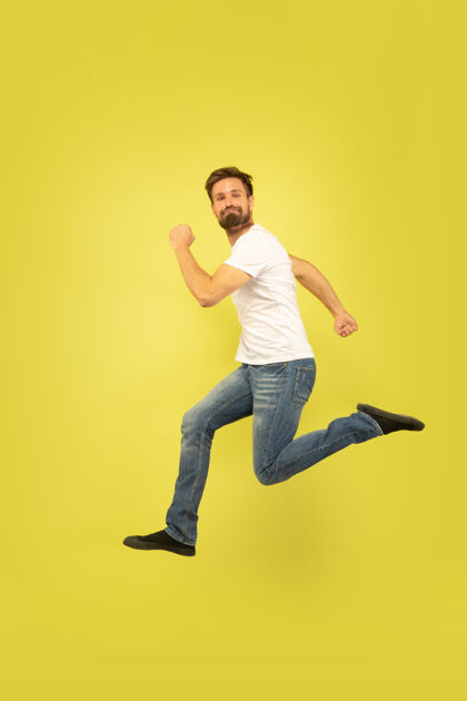 跳跃黄色背景上孤立的快乐跳跃人的全长肖像穿着休闲服的白人男模自由选择 灵感 人类情感概念快乐奔跑服装男性休闲