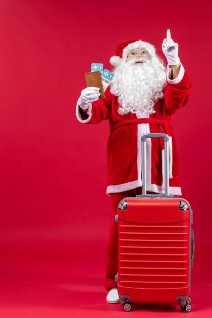 圣诞圣诞老人的前视图 带着包 拿着票 准备在红墙上旅行冬天包圣诞快乐