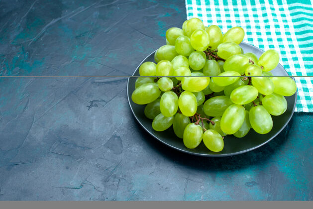 水果半顶视图新鲜的绿色葡萄醇厚多汁的水果在深蓝色桌板内水果蓝色藤蔓