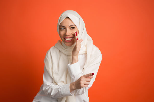 宗教秘密 八卦概念戴头巾的快乐阿拉伯女人微笑女孩的肖像 在红色工作室背景摆姿势年轻的情感女人人类情感 面部表情概念正面视图头巾快乐肖像