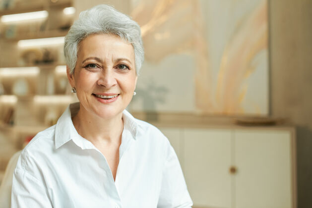 专业一位成功的中年女商人的室内肖像 她留着一头灰色的短发 在办公室工作灰色老年公司