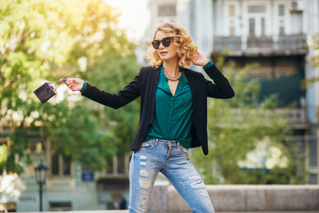 太阳镜优雅漂亮的女人戴着墨镜 夹克 牛仔裤 绿色衬衫 春日时尚潮流 手拿小包 女性肖像城市