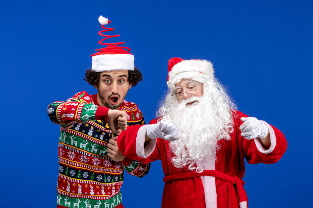 人们正面图：圣诞老人和年轻的男性站在一起年轻人男性