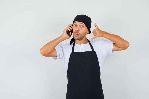 年轻人穿t恤 围裙的面包师在讲手机食物烘焙男人