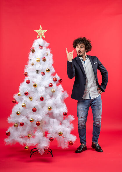 快乐圣诞庆祝快乐有趣兴奋的年轻人作出胜利的姿态 站在圣诞树附近站立成人时尚