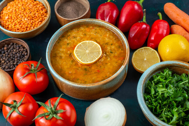 西红柿在深蓝色的桌子上 可以近距离看到美味的蔬菜汤 还有新鲜的蔬菜 蔬菜和调味品胡椒顶部调味品