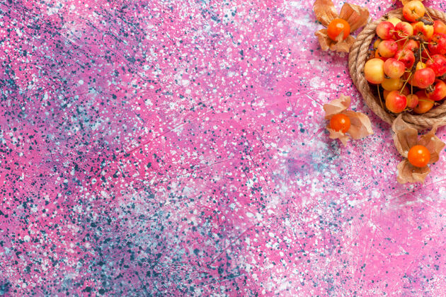 新鲜在浅粉色的桌子上用绳子顶着新鲜的甜樱桃水果表面浅粉色