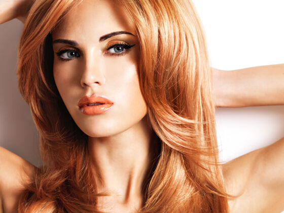 姜黄色长着红色直发的漂亮女人完美化妆闪亮