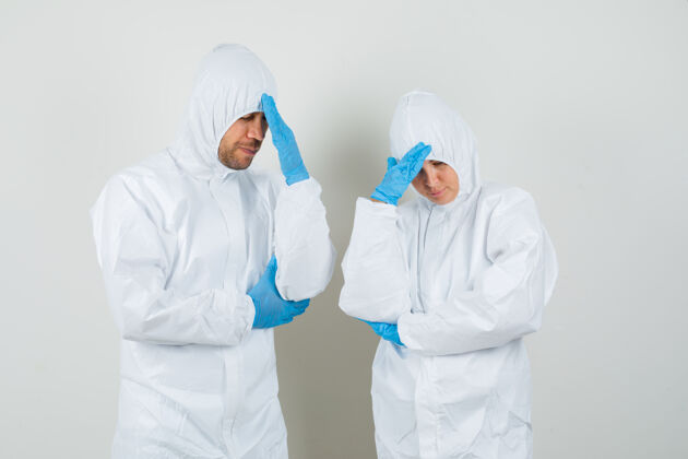 男性两个医生穿着防护服 戴着手套揉着头 看上去很失望人专家护理