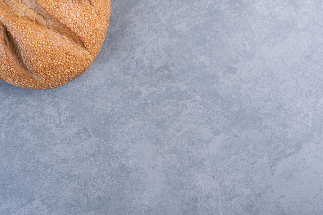 视图在大理石上涂上芝麻的面包面包皮面包屑面包
