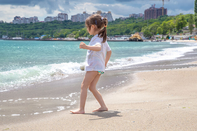 城市小可爱的女孩在阳光明媚的日子在海边的海滩上女孩夏天风景
