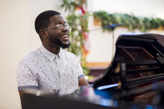 演奏一个男人在弹钢琴时微笑的浅焦镜头演奏音乐家钢琴