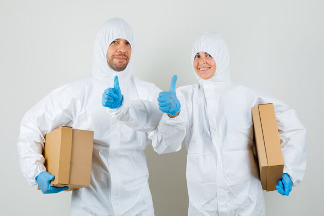 女性两个医生穿着防护服 戴着手套拿着纸板箱医药医院肖像